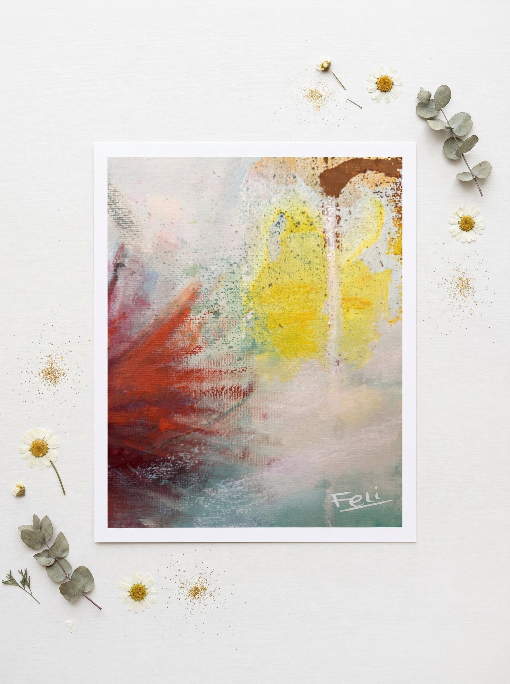 Touching the sky by feli the artist is An abstract art print featuring a textured composition of yellow, red, brown, and teal paint strokes on a white background, styled with dried flowers and eucalyptus leaves on a white surface.