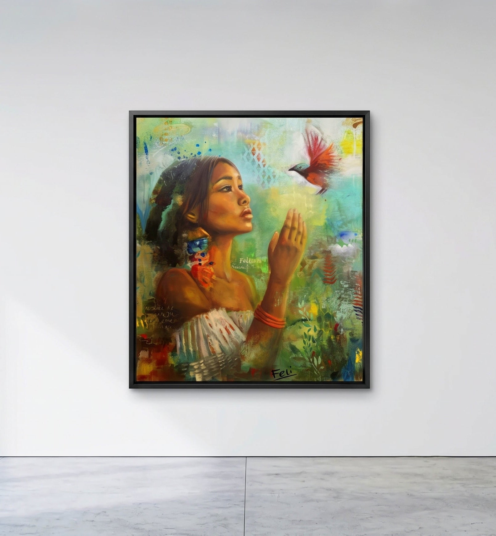 If I had wings by Feli the artist An expressive framed art print of a mixed race asian native woman with her hands raised toward a small red bird in flight, rendered in rich greens, blues, browns, and warm skin tones with textured brushstrokes and layered collage elements hang on white wall.