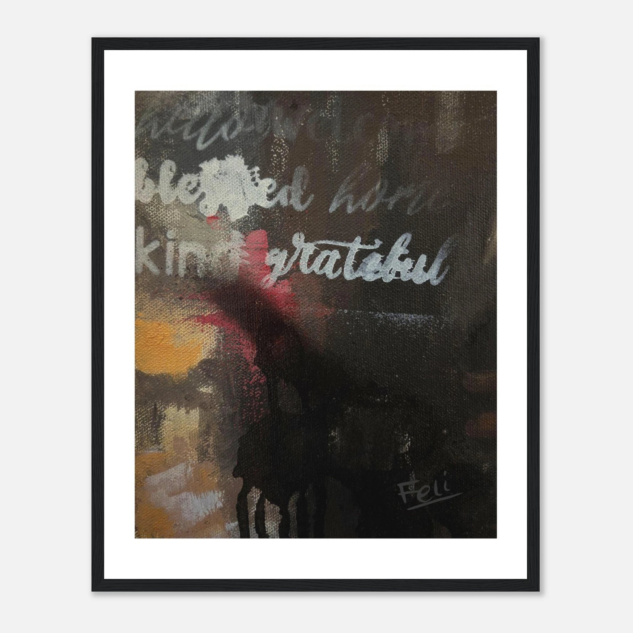 A framed abstract art print titled grateful and blessed by feli the artist featuring the words 'blessed', 'kind', and 'grateful' in white script over a dark, textured background with yellow and red accents, displayed in a black frame on a light gray wall.