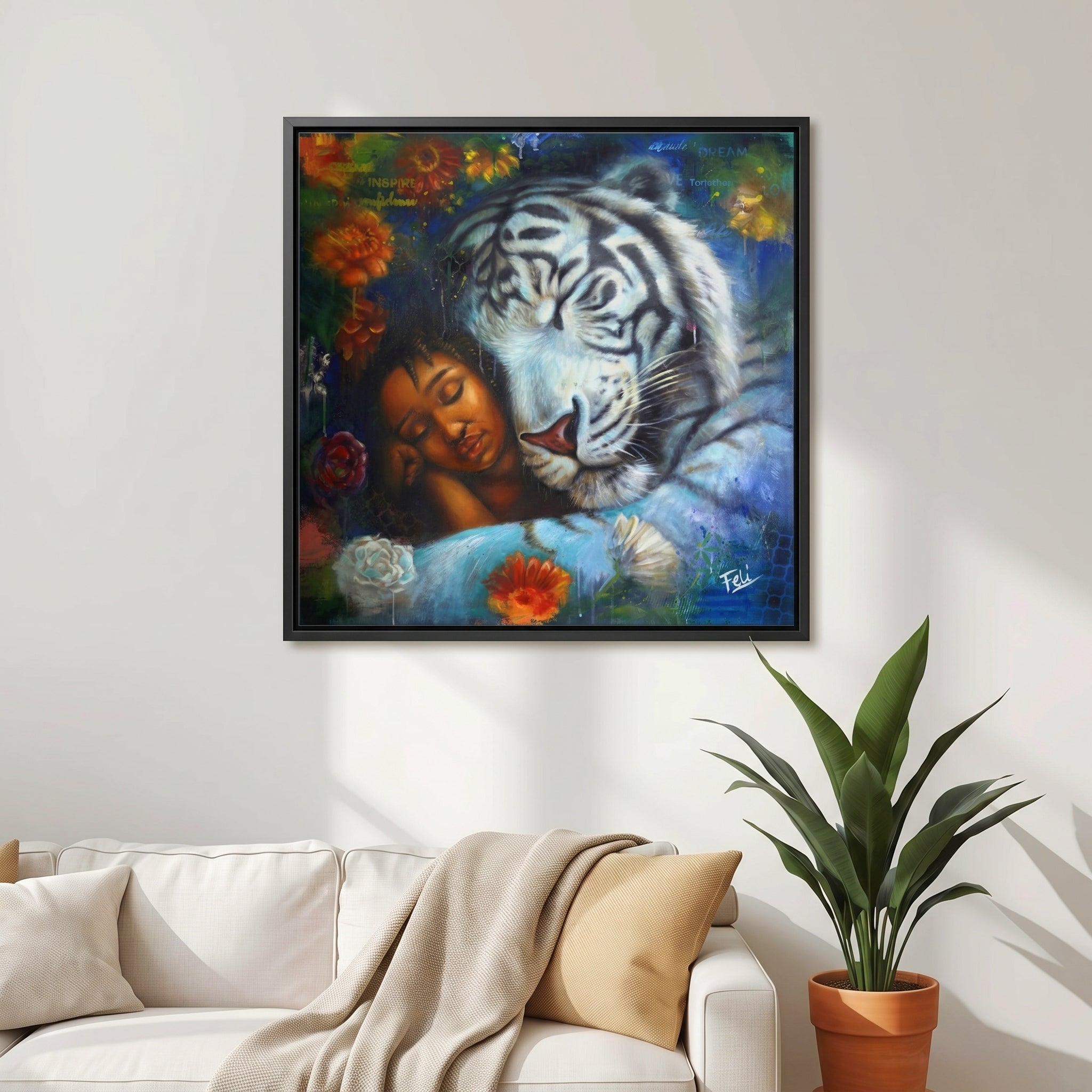 Wild heart gentle soul by feli the artist A framed art print hang on a livingroom wall showing a sleeping woman resting her head against a large white tiger, surrounded by colorful flowers and dark blue background tones.